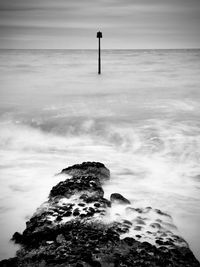 Rock formation on sea shore against sky
