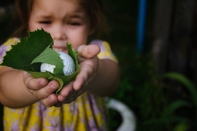 Cute girl giving leaves and golf ball