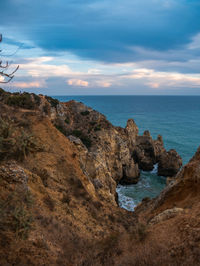 Rock formations on sea shore against sky