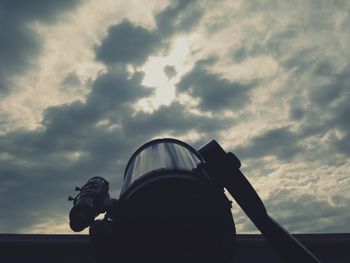 Photographer photographing against cloudy sky