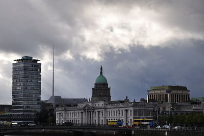 Buildings in city against cloudy sky