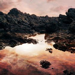 Scenic view of lake against cloudy sky