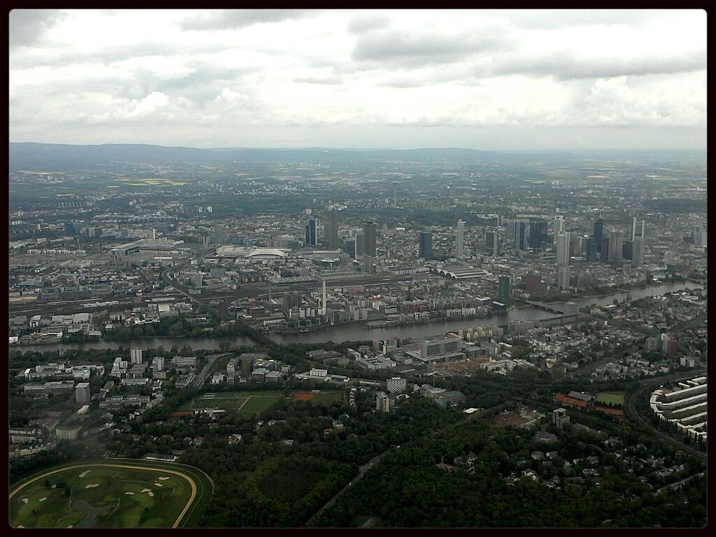 AERIAL VIEW OF CITYSCAPE AGAINST CLOUDY SKY