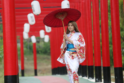 Woman standing with red umbrella