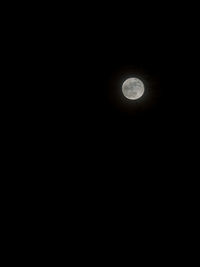 Low angle view of illuminated moon against sky at night