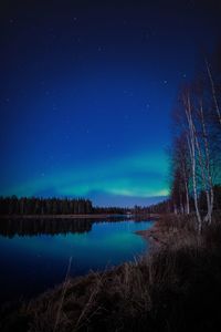 Scenic view of lake against sky at night