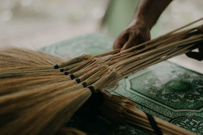 Close-up of person working on handcrafted walis tambo or brooms