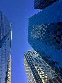 Low angle view of modern buildings against clear blue sky