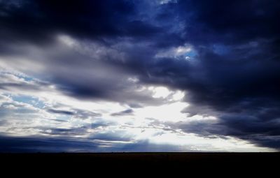 Silhouette landscape against cloudy sky