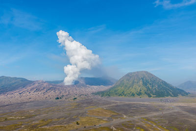 Smoke emitting from volcanic mountain against sky