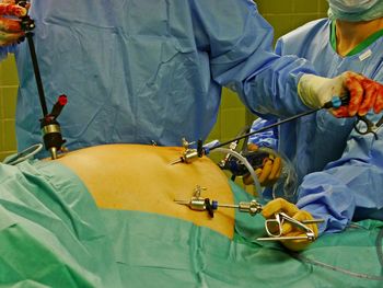 Midsection of surgeons operating patient in hospital