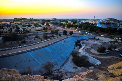 High angle view of river amidst buildings in city at sunset