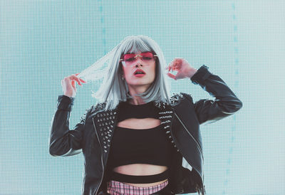 Portrait of young woman standing against abstract backgrounds