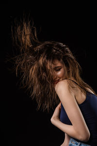 Portrait of a beautiful young woman over black background