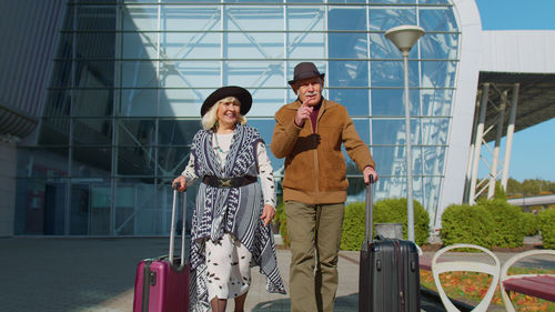 Senior couple holding suitcase at airport