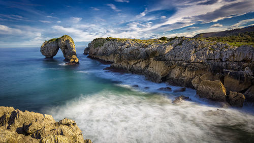 Rocks in sea against sky