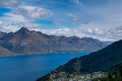 Scenic view of lake and mountains against blue sky