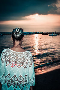 Rear view of woman looking at sea against sky