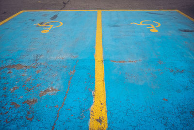 High angle view of blue disabled road marking in parking lot