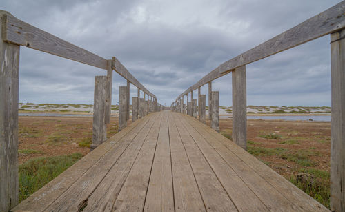 Footbridge over land against sky