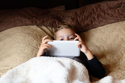 High angle view of child lying on bed at home