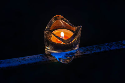 Close-up of illuminated candle against black background