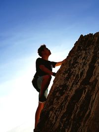 Low angle view of man on rock against sky