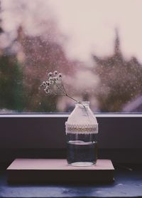 Close-up of bottle on table by window