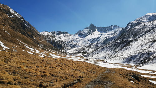 Scenic view of snowcapped mountains against blue sky
