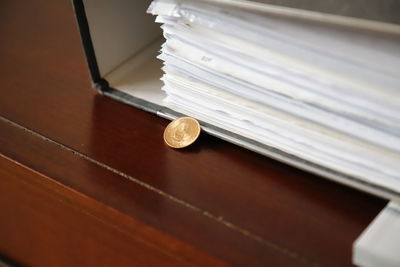 Close-up of coin by file on table