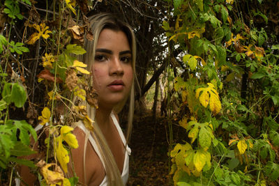 Portrait of young woman looking at plants