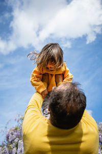 Father holds baby high in the sky