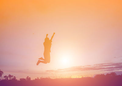 Silhouette man jumping against sky during sunset