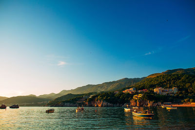 Scenic view of sea and mountains against blue sky