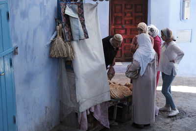 Rear view of people standing at market