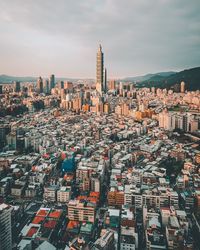 High angle view of city buildings against cloudy sky