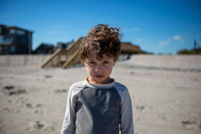 Portrait of angry boy standing on beach