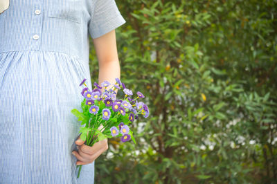 Midsection of woman holding flowers