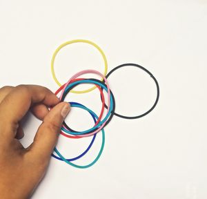Close-up of hand holding eyeglasses against white background