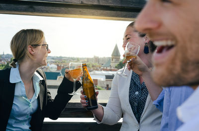 Young man drinking from glass while standing outdoors