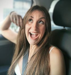 Portrait of young woman sitting in car