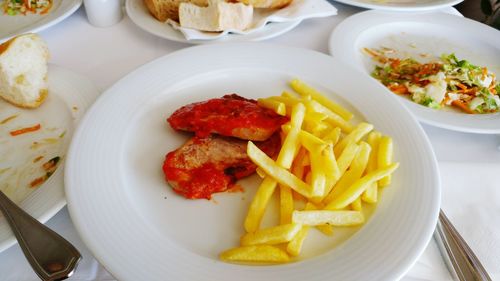 Close-up of meat with french fries in plate on table