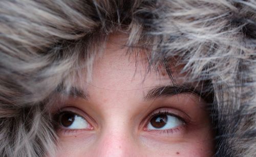 Cropped image of thoughtful woman wearing fur coat