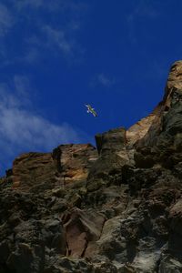 Low angle view of rocks against blue sky