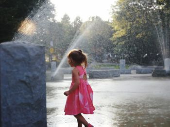 Rear view of girl looking at waterfall