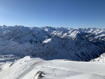 Scenic view of snowcapped mountains against clear blue sky