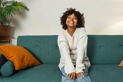 Young woman sitting on sofa at home