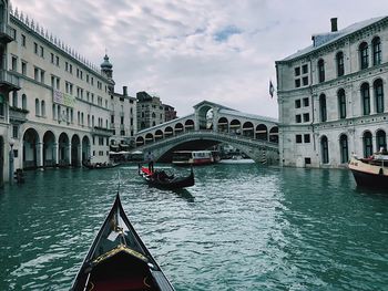 Gondola in canal against buildings