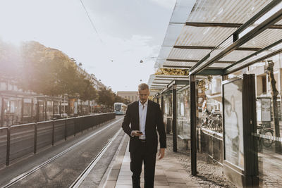 Businessman walking and using cell phone