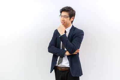 Full length of young man standing against white background